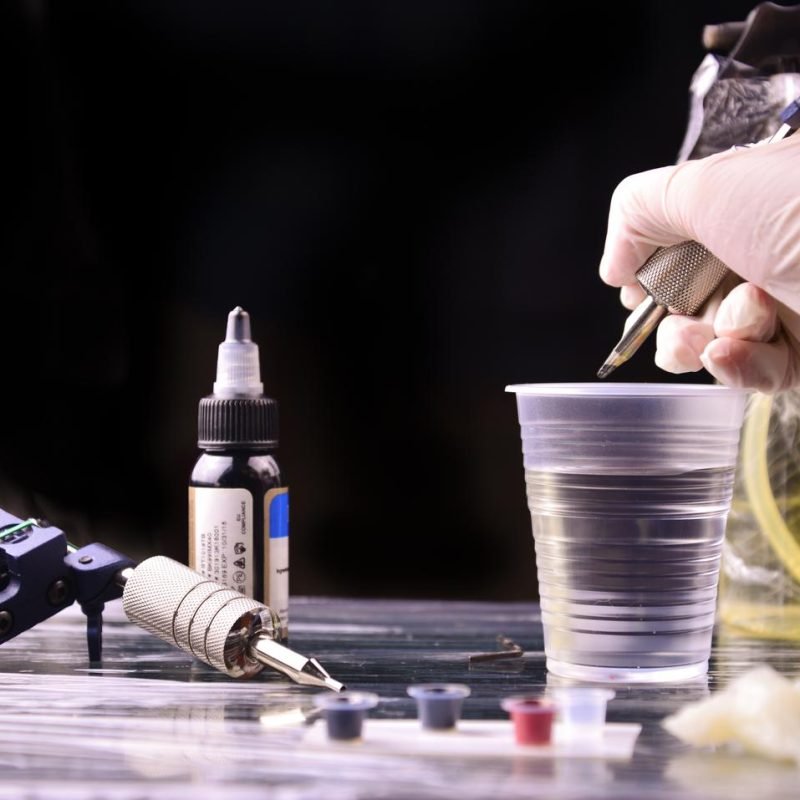 Man wearing gloves makes tattoo pictures in salon